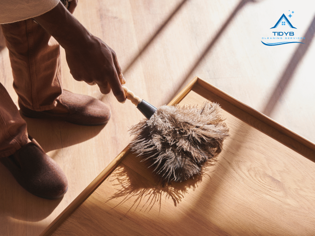 Uniformed cleaner vacuuming and dusting a client’s home