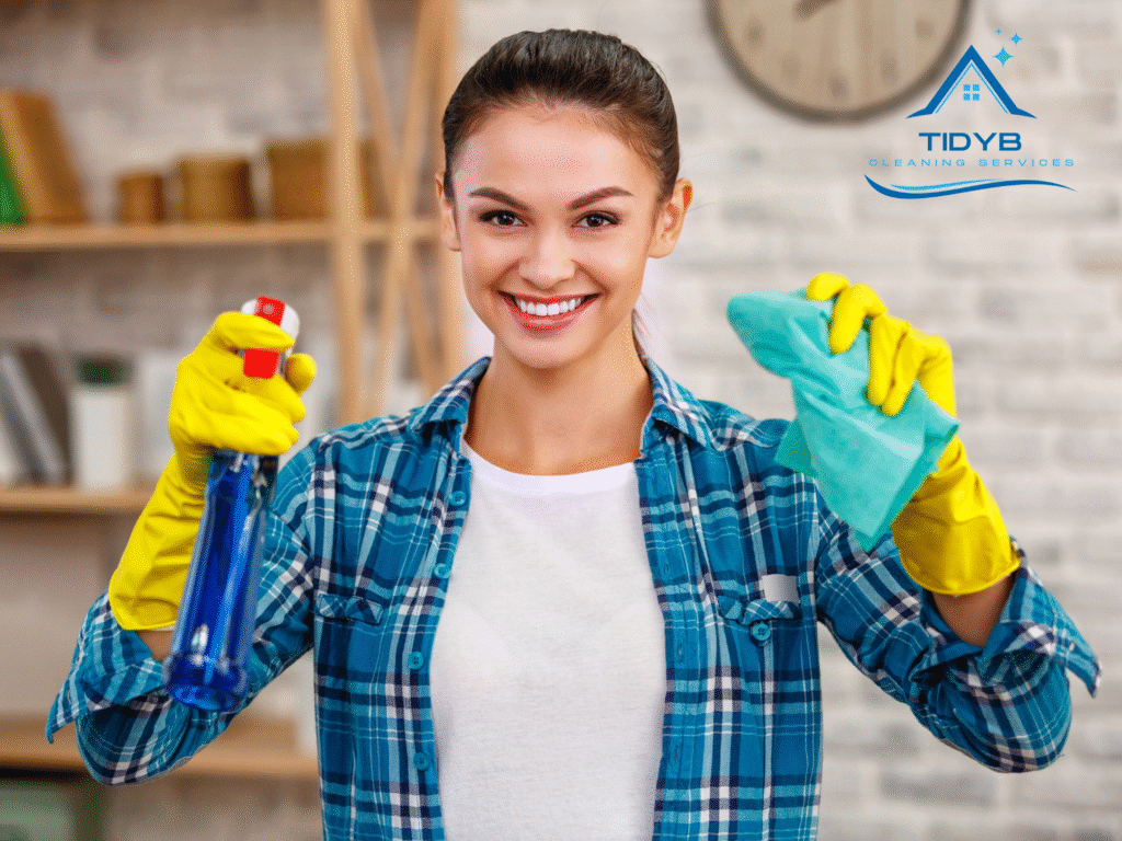 Smiling professional cleaner holding cleaning tools, ready to start cleaning